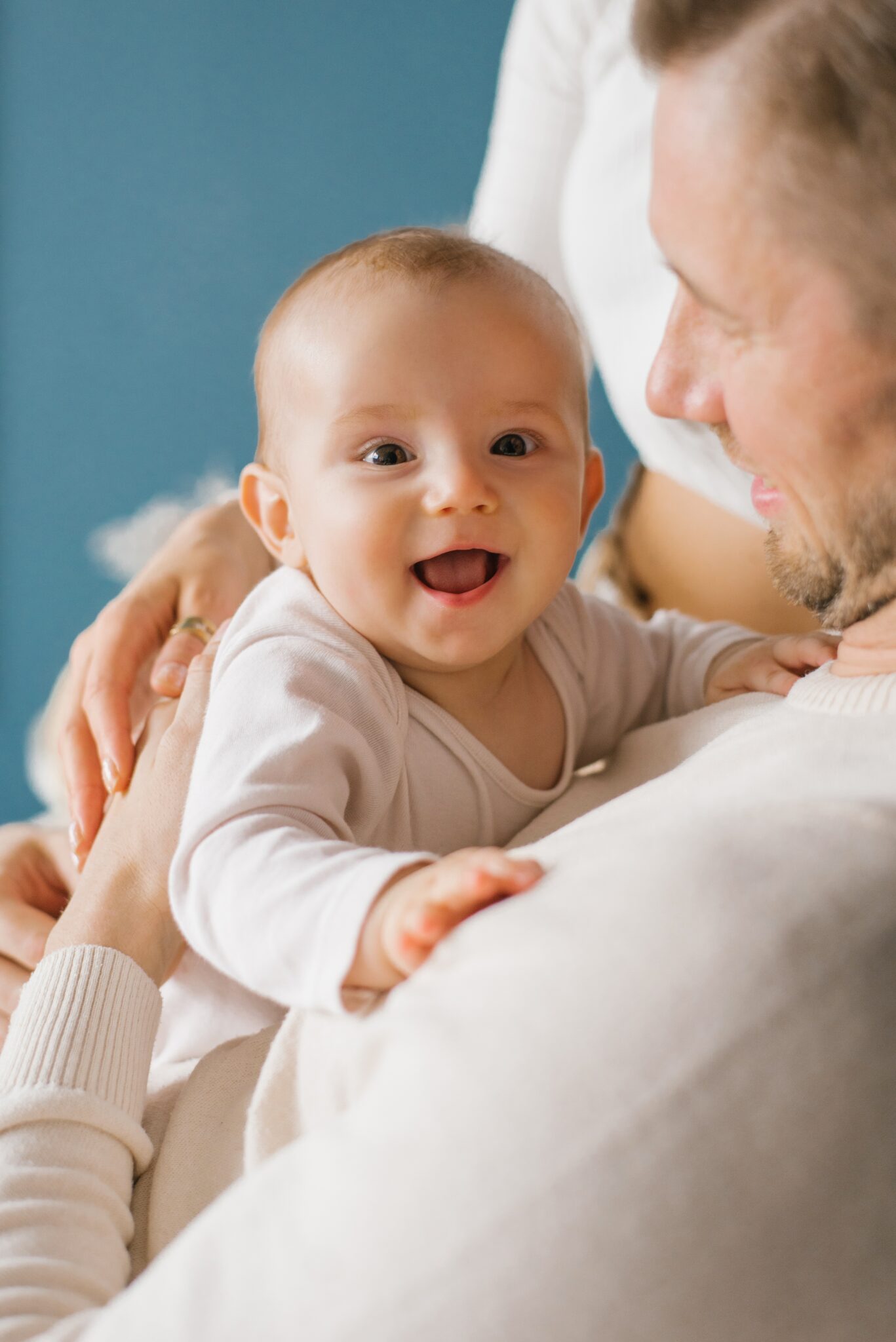 Home a smiling baby in the arms of his young happy dad