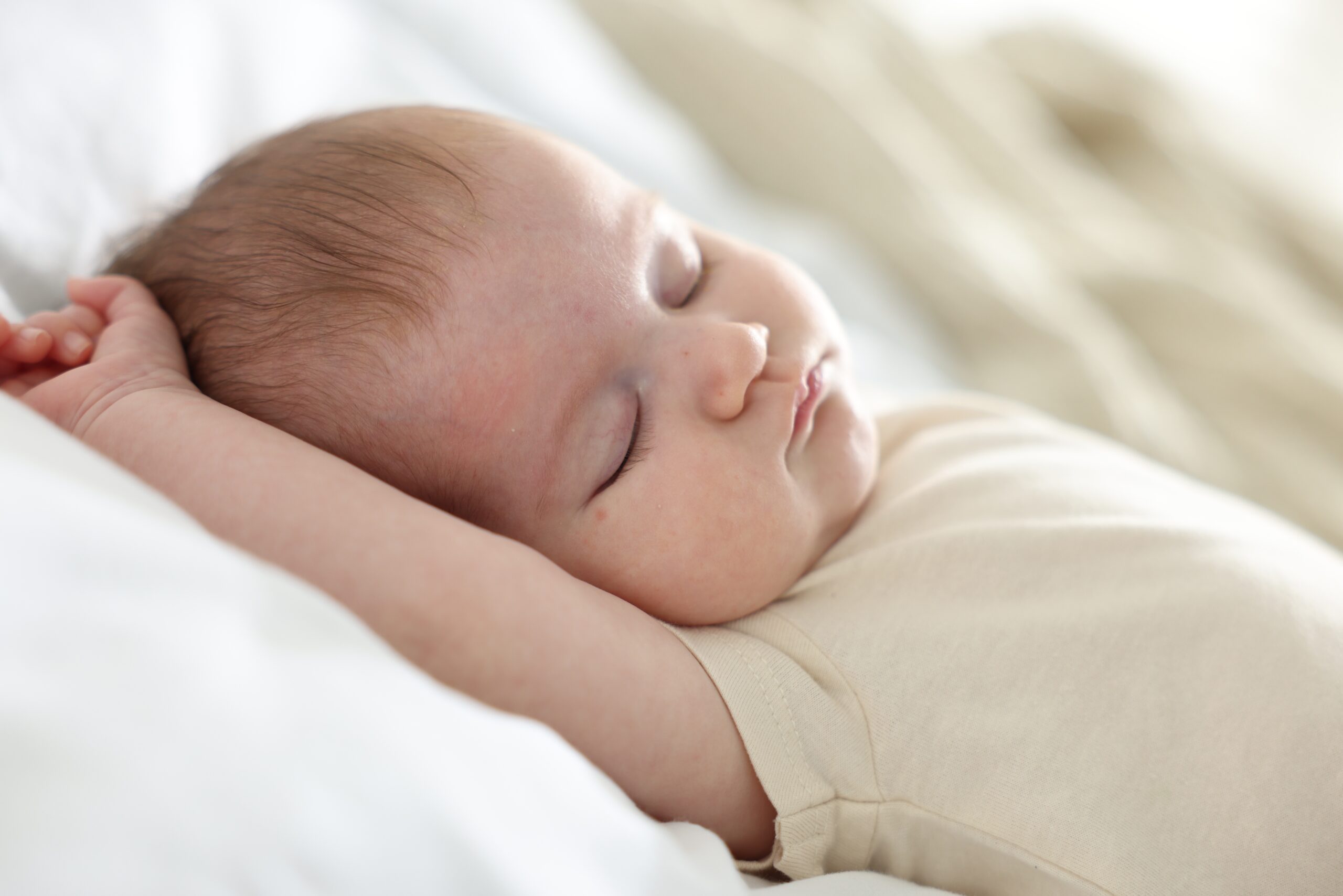 Home cute newborn baby sleeping on bed indoors
