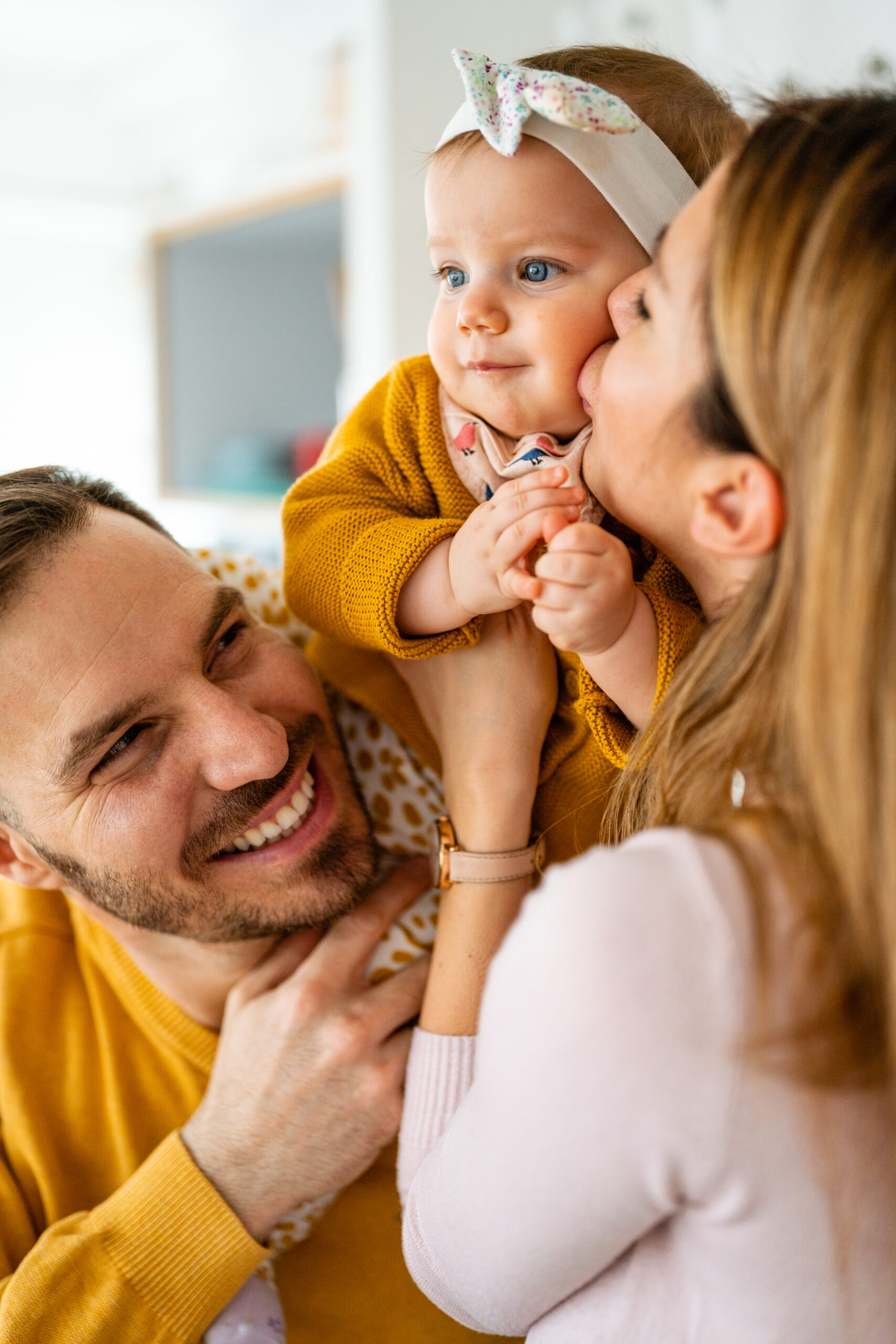 Home proud mother and father smiling at their baby daughter at home